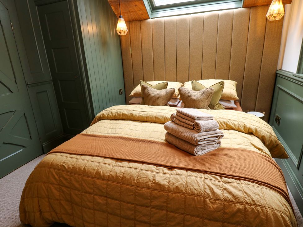 A bedroom with a bed and towels on a bedside table at White House in Durham