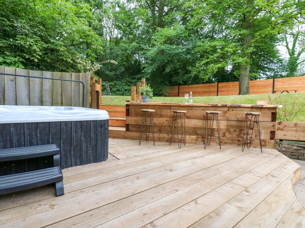 An outdoor area with a hot tub and a wooden bar at White House in Durham