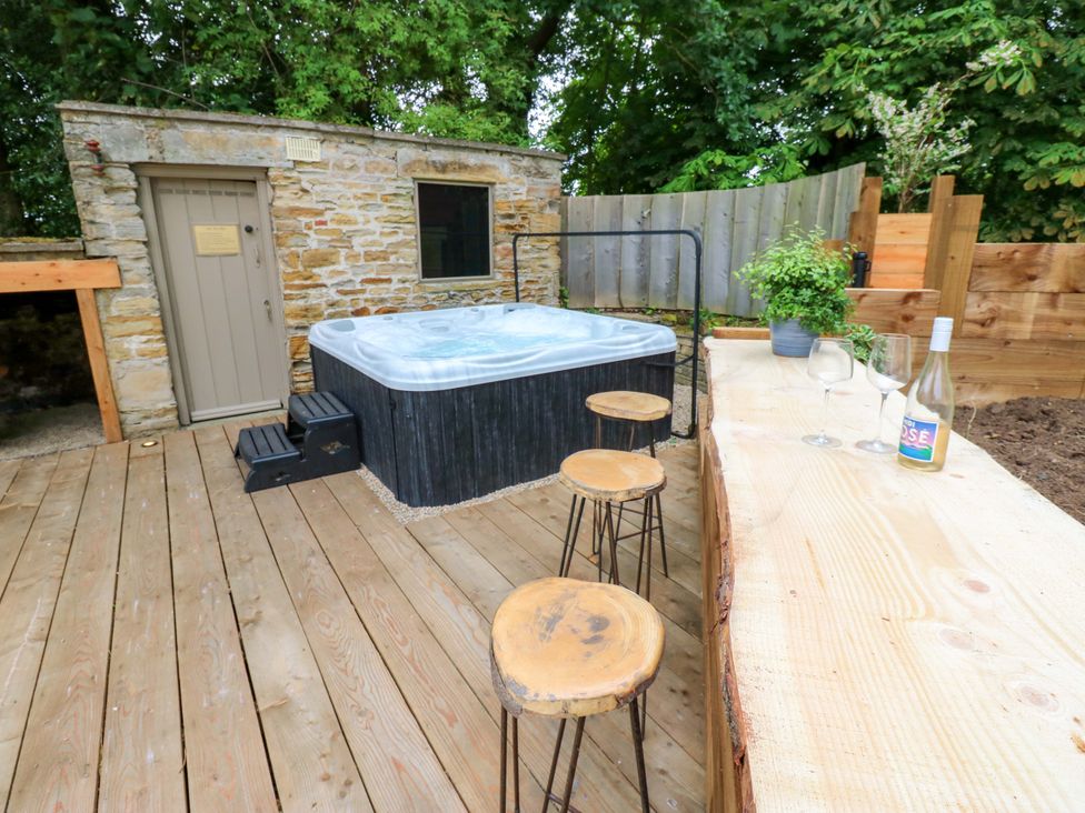 An outdoor space with a hot tub and wooden stools at White House in Durham