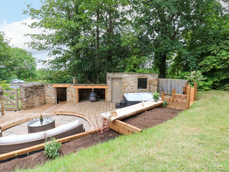 An outdoor deck with a hot tub and furniture at White House in Durham