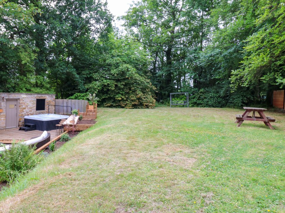 A garden with a hot tub, wooden bench, and picnic table at White House in Durham