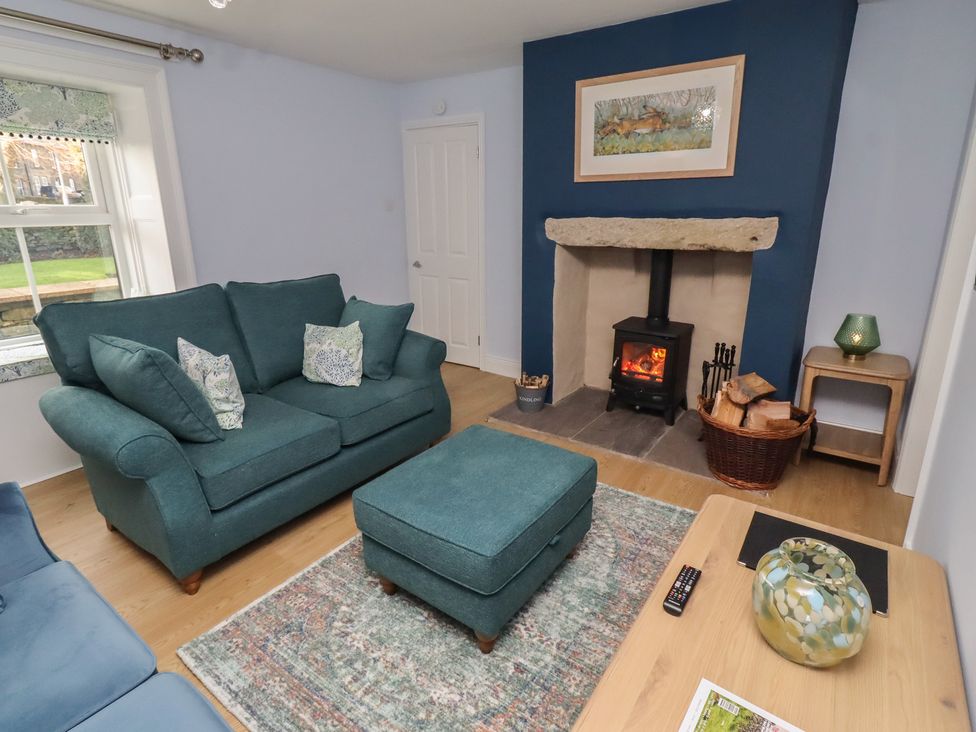 A living room with a sofa and fireplace at Linn Cottage in Hexham