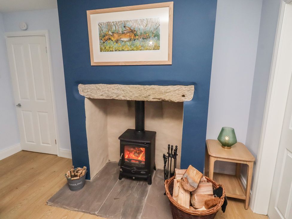 A living room with a fireplace and wood stove at Linn Cottage Hexham