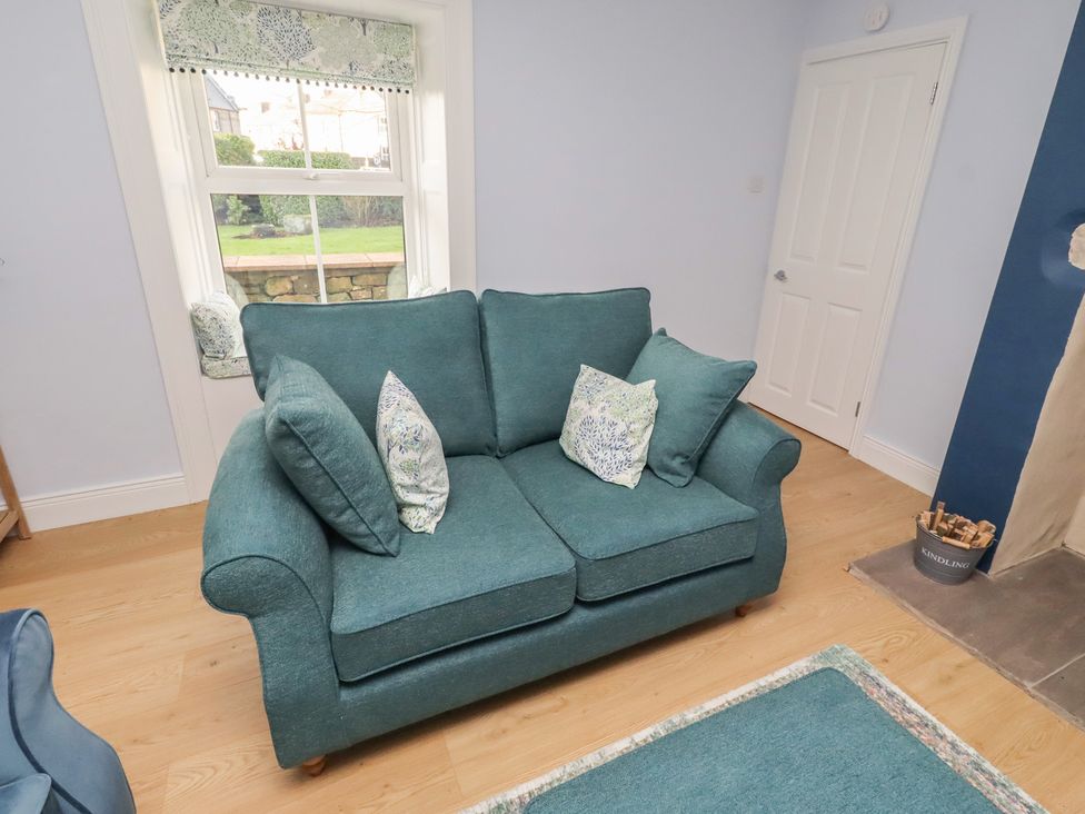 A living room with a sofa and window at Linn Cottage Hexham