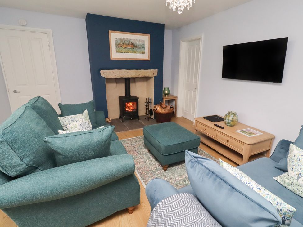 A living room with a sofa and television at Linn Cottage in Hexham
