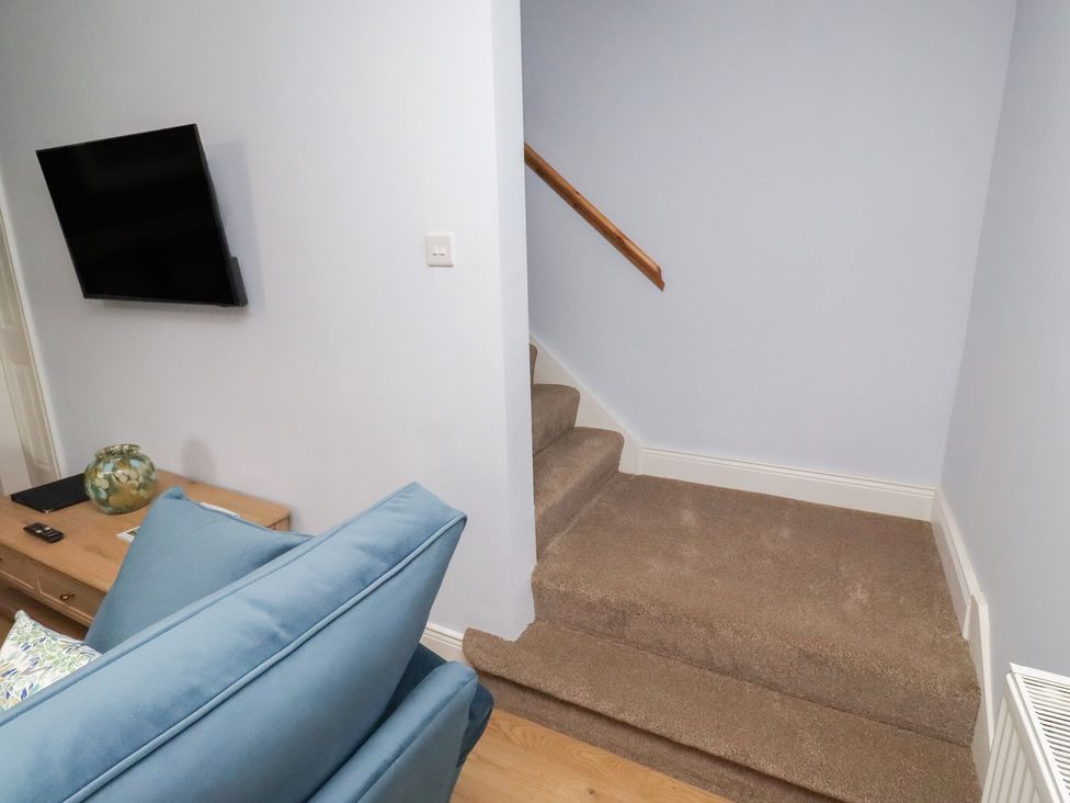 A living room with a television and sofa at Linn Cottage Hexham