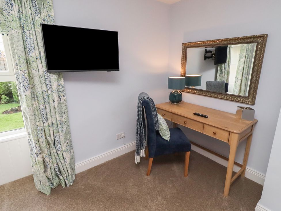 A bedroom with a desk and a chair at Linn Cottage in Hexham