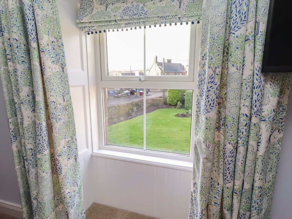A window with curtains in a living room at Linn Cottage in Hexham