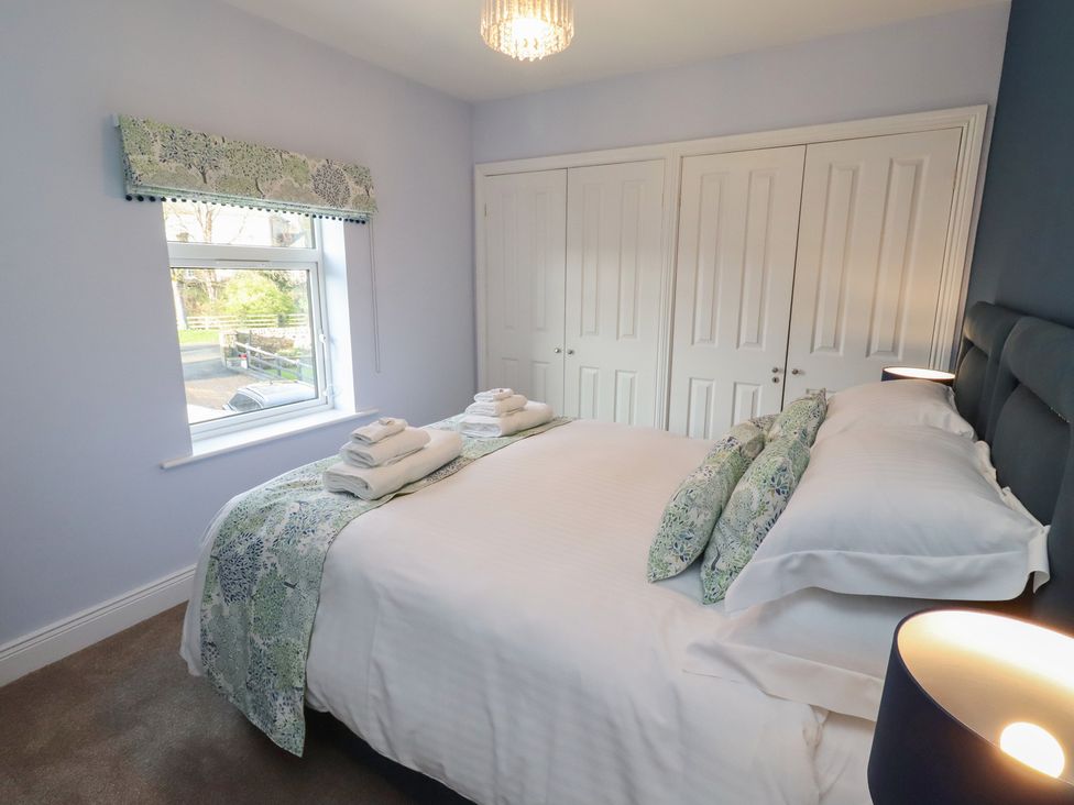 A bedroom with bedding and towels at Linn Cottage in Hexham