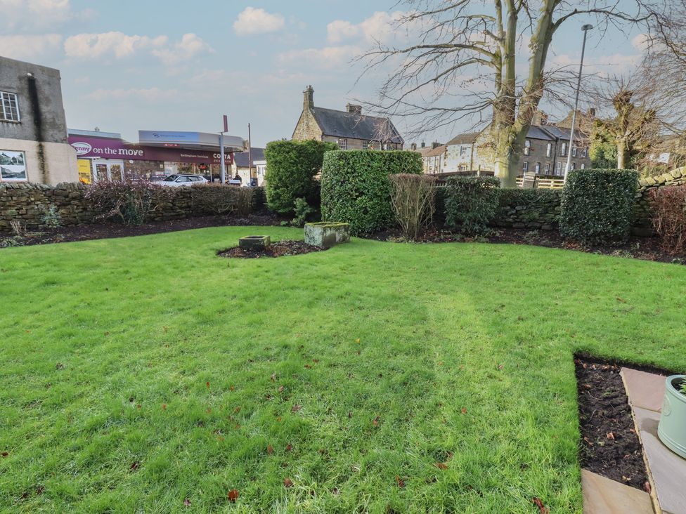 A garden with grass and stone wall at Linn Cottage Hexham
