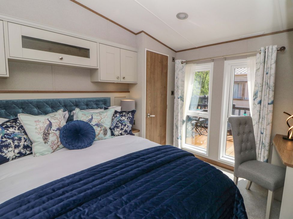 A bedroom with a bed and windows at The Beaumont No 34 in New Quay