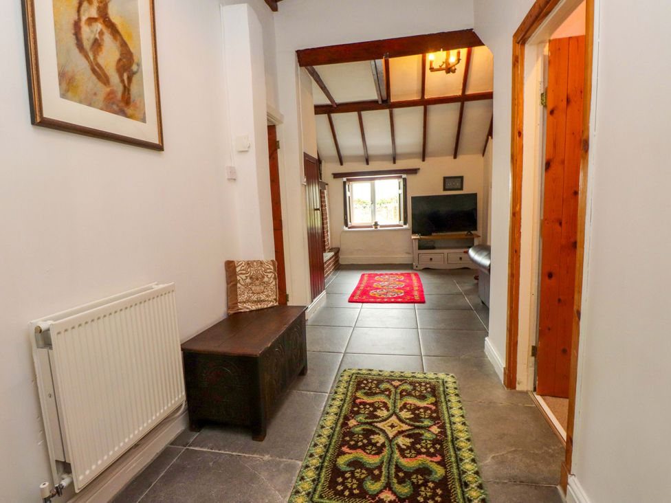 A hallway with a radiator, bench, and television at 2 Llainwen in Ty Croes