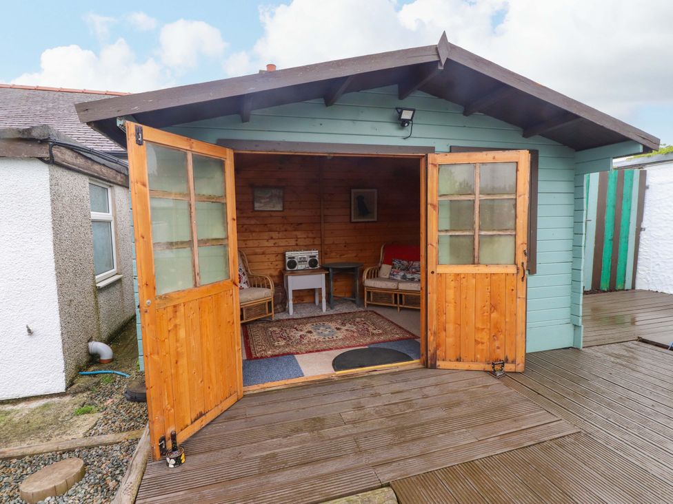 An outdoor garden shed with seating and a radio at 2 Llainwen Ty Croes