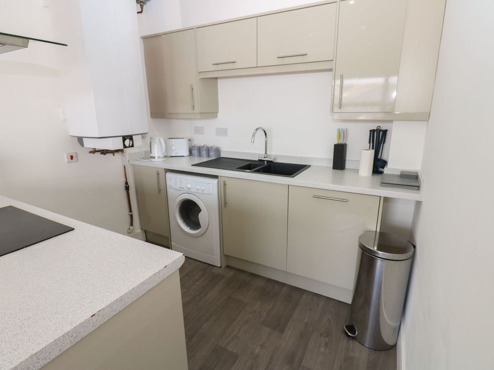 A kitchen with a washing machine and sink at Harbour View in Whitehaven