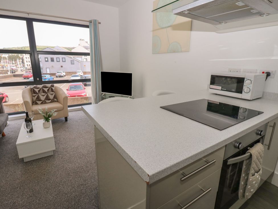 A living room with a kitchen area and sofa at Harbour View in Whitehaven