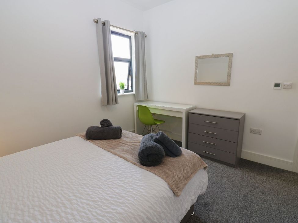 A bedroom with a bed, desk, and drawer unit at Harbour View in Whitehaven