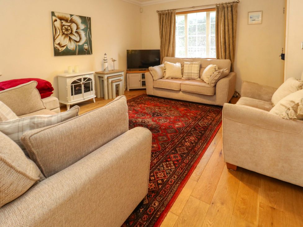 A living room with sofas and a coffee table at Fairways House in Weymouth