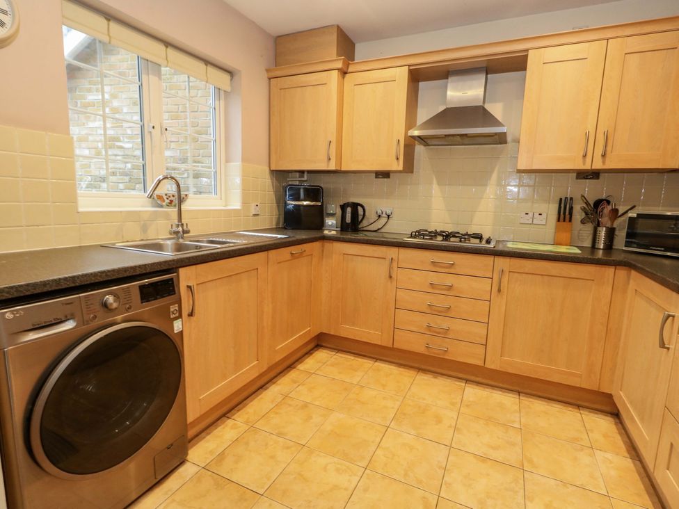 A kitchen with cabinets and appliances at Fairways House in Weymouth