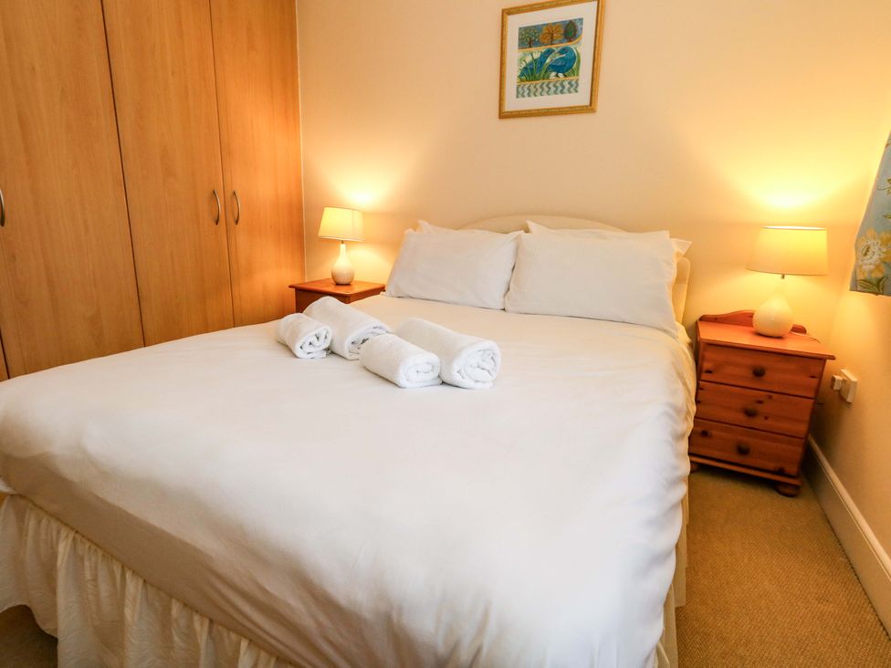 A bedroom with a bed and bedside tables at Fairways House in Weymouth