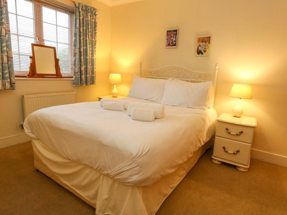 A bedroom with a bed and bedside table at Fairways House in Weymouth