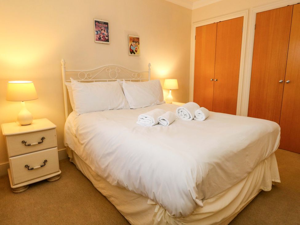 A bedroom with a bed and bedside table at Fairways House in Weymouth
