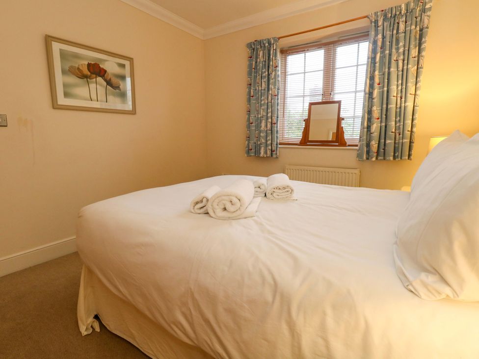 A bedroom with a bed and towels on it at Fairways House in Weymouth