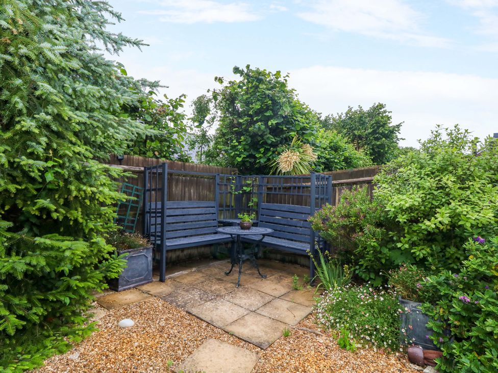 A garden with seating area and plants at Fairways House in Weymouth