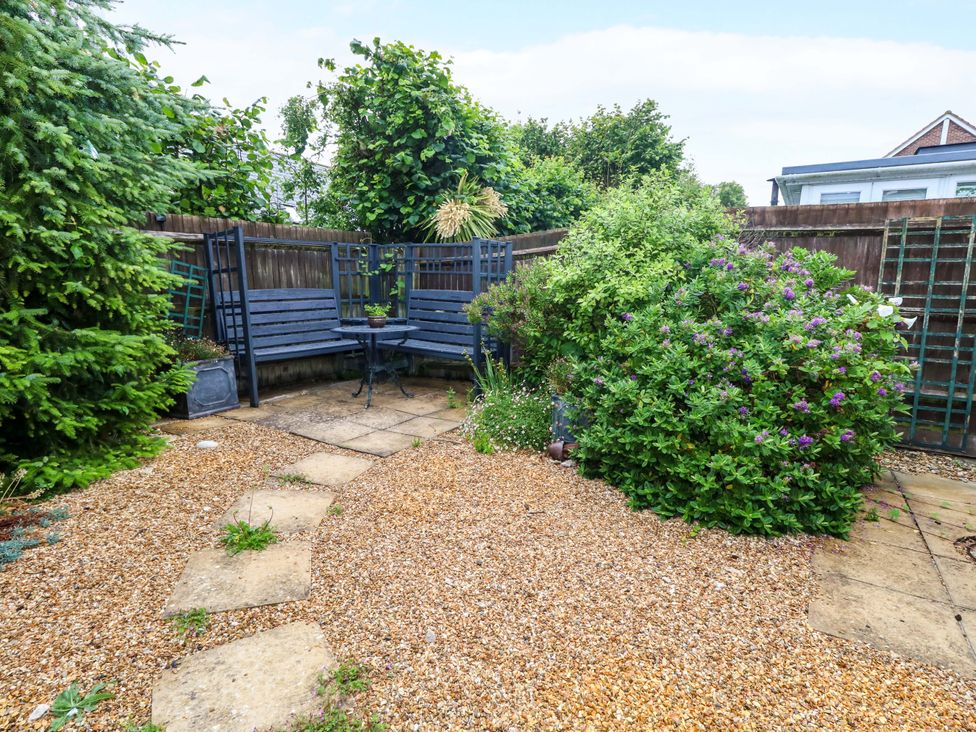 A garden with gravel path and seating area at Fairways House Weymouth