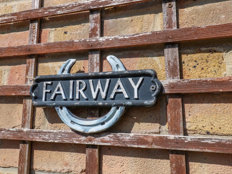 A decorative sign on a trellis wall at Fairways House in Weymouth