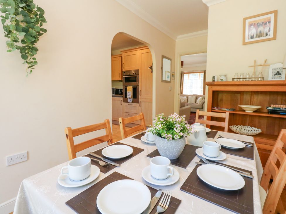 A dining room with a table set for tea at Fairways House in Weymouth
