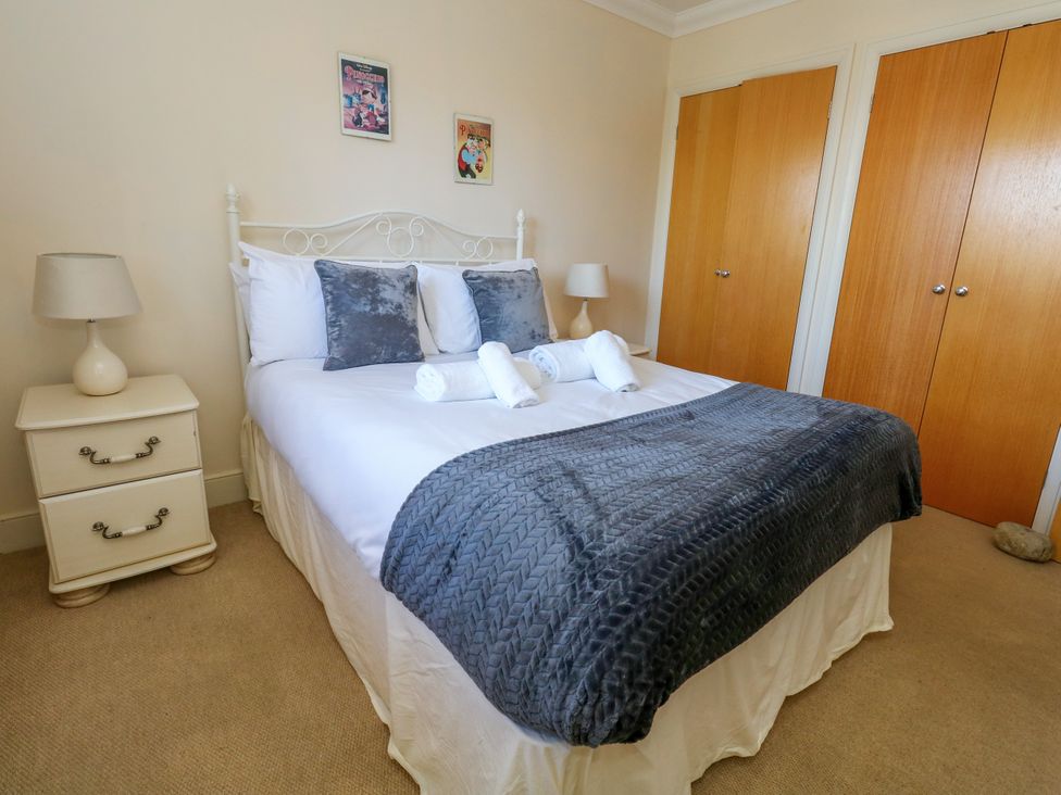 A bedroom with a bed and nightstand at Fairways House in Weymouth