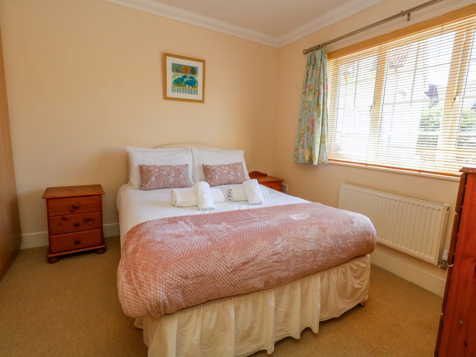 A bedroom with a bed and bedside tables at Fairways House in Weymouth