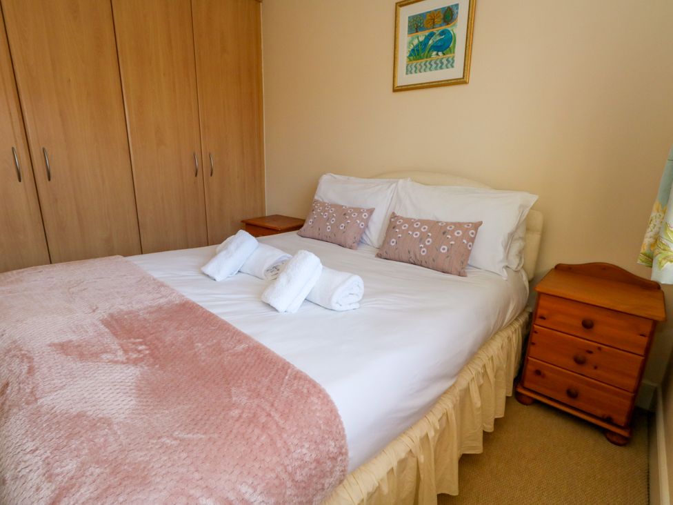 A bedroom with a bed and wardrobe at Fairways House in Weymouth