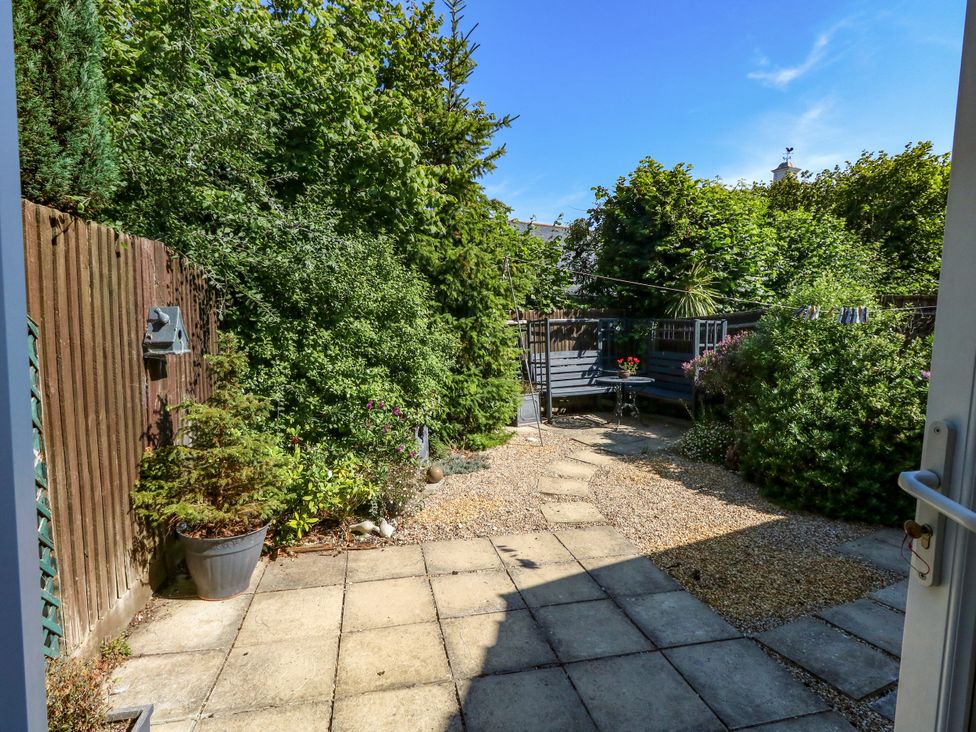 A garden with plants, a table, and a chair at Fairways House in Weymouth