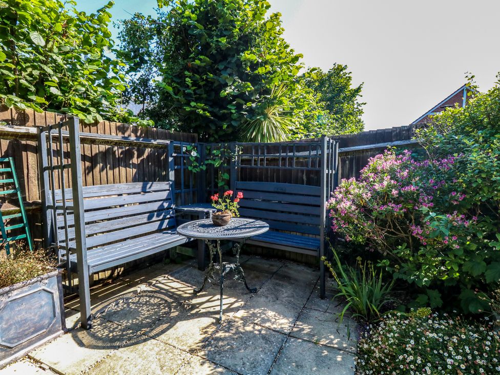 A garden with seating area and a table at Fairways House in Weymouth