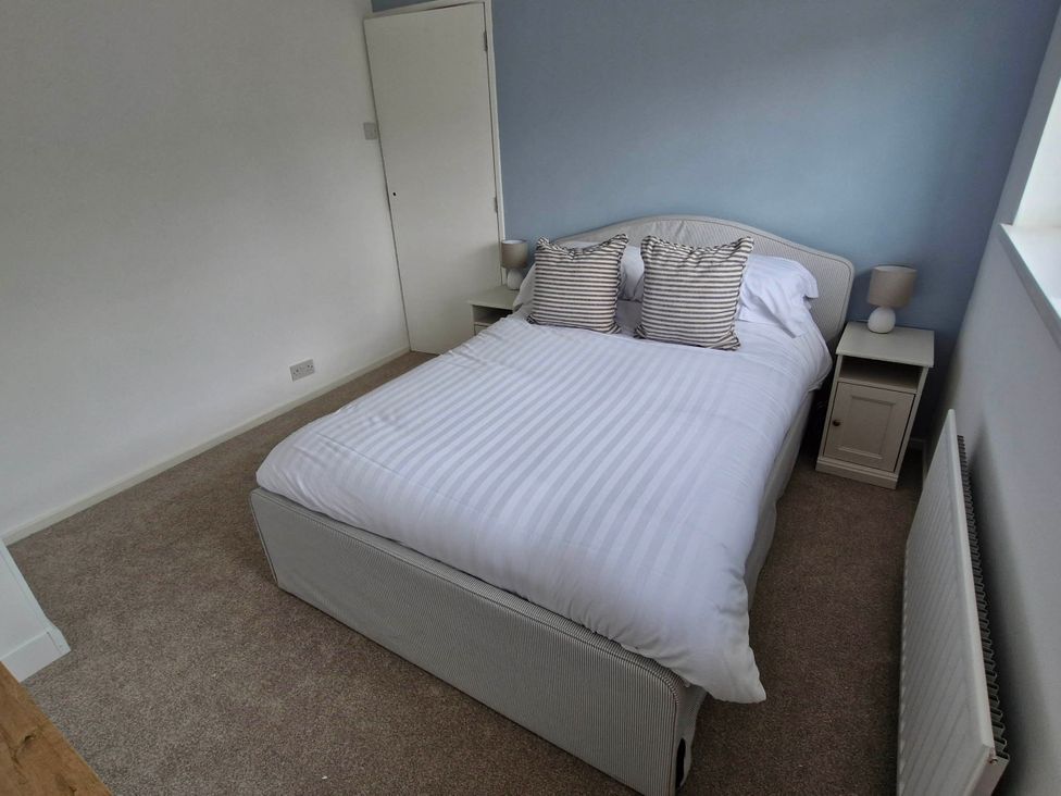 A bedroom with a bed and bedside tables at 13 Seafield Road