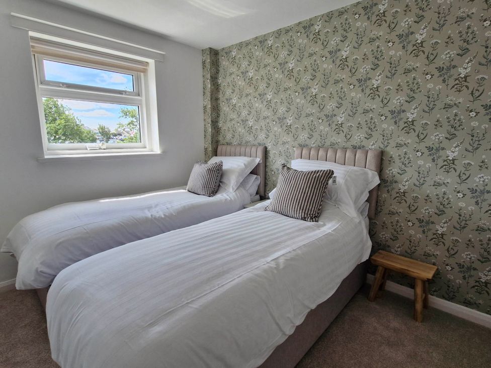 A bedroom with two beds and a window at 13 Seafield Road