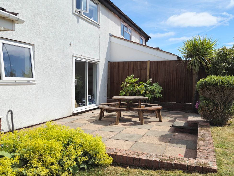 A garden area with a patio and wooden table at 13 Seafield Road