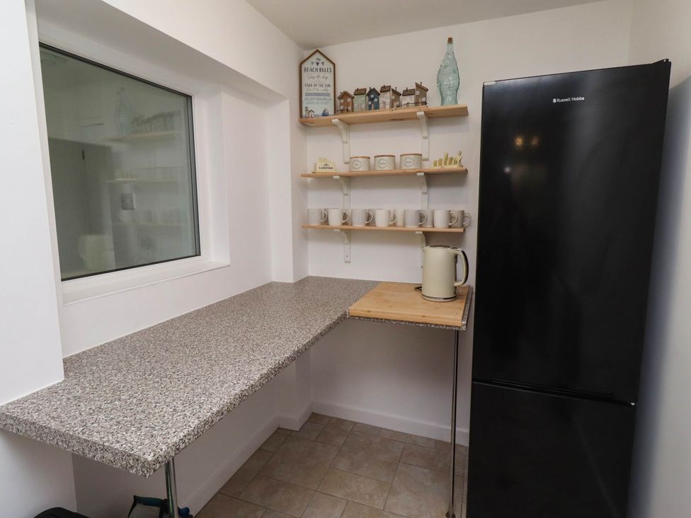 A kitchen with a countertop and a refrigerator at Bari House in Seahouses