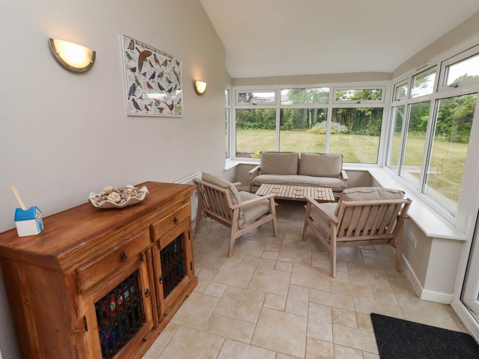 A conservatory with seating and a cabinet at Bari House in Seahouses