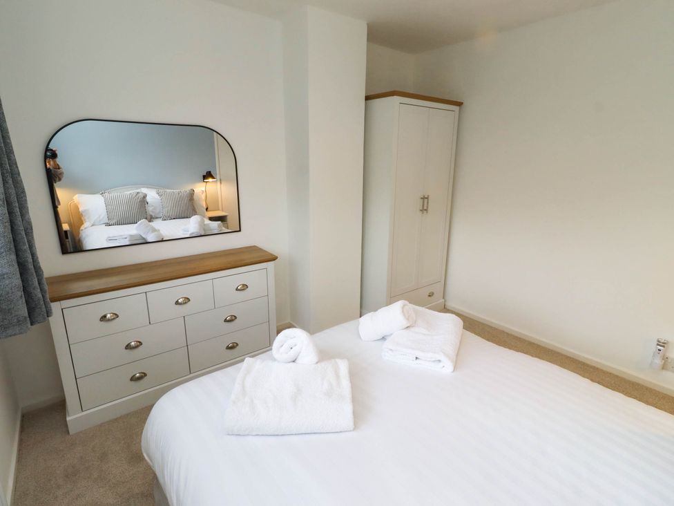 A bedroom with a bed and dresser at Bari House in Seahouses