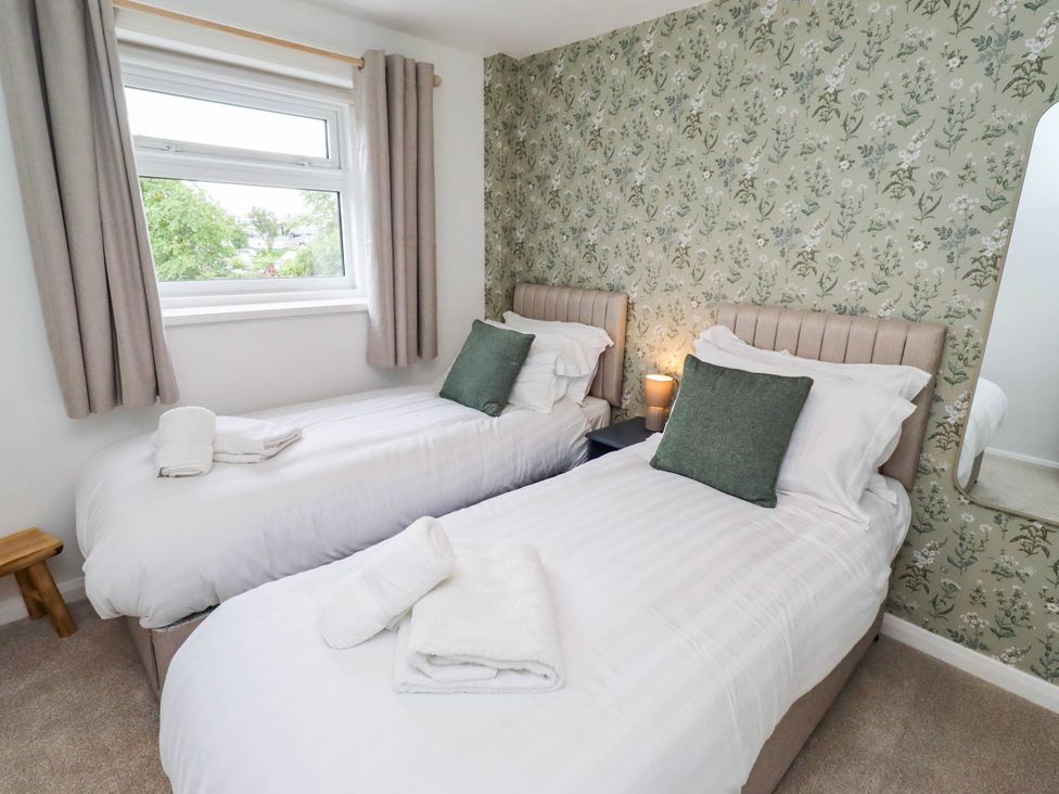 A bedroom with two beds and a window at Bari House in Seahouses