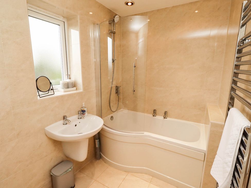 A bathroom with a bathtub and sink at Bari House in Seahouses