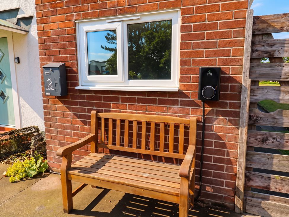 A bench next to a mailbox and charger at Bari House in Seahouses