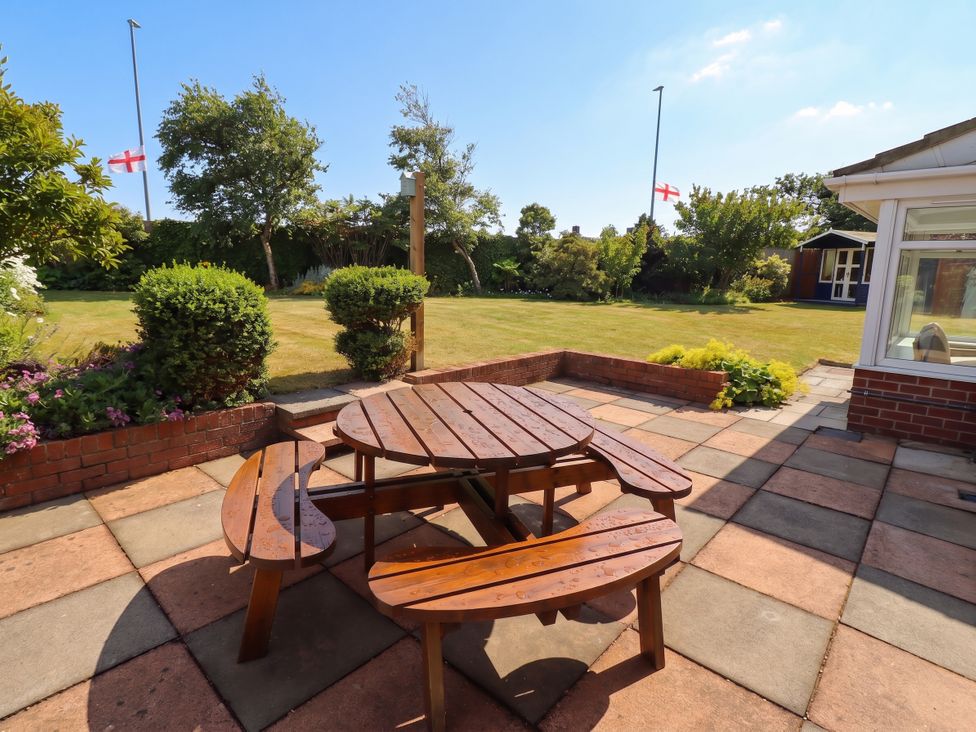 A garden with a wooden table and benches at Bari House in Seahouses