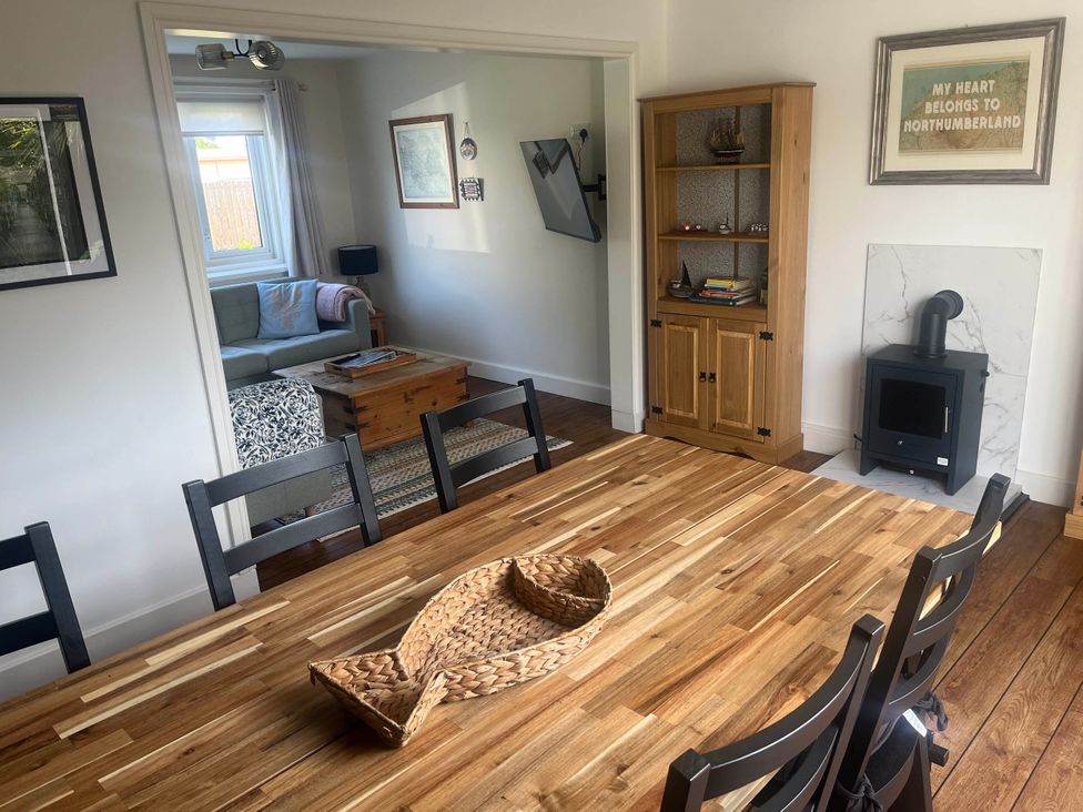 A dining room with a wooden table and chairs at Bari House in Seahouses