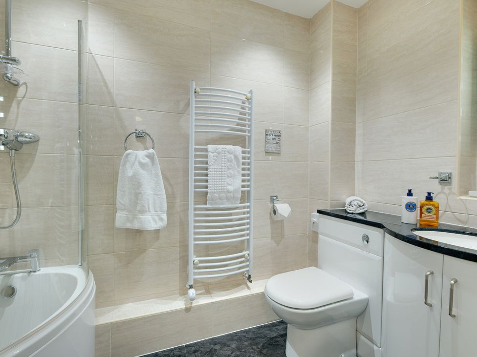 A bathroom with a shower, toilet, and wash basin at The Granary in Alnwick