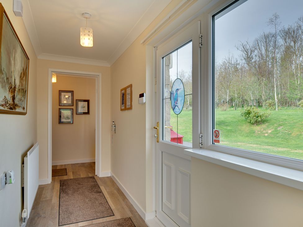 A hallway with a door and window at The Granary in Alnwick