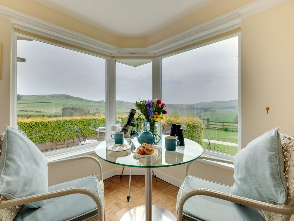A dining area with a table, chairs, and view at The Granary in Alnwick