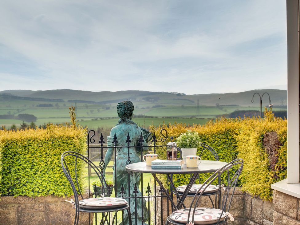 An outdoor seating area with a table and statue at The Granary in Alnwick